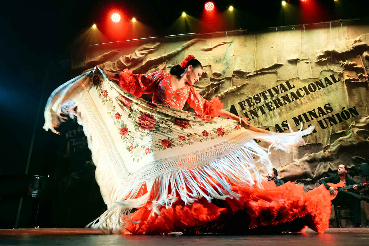 Bailaora flamenca con mantón rojo actuando en el Festival Internacional del Cante de las Minas de La Unión.