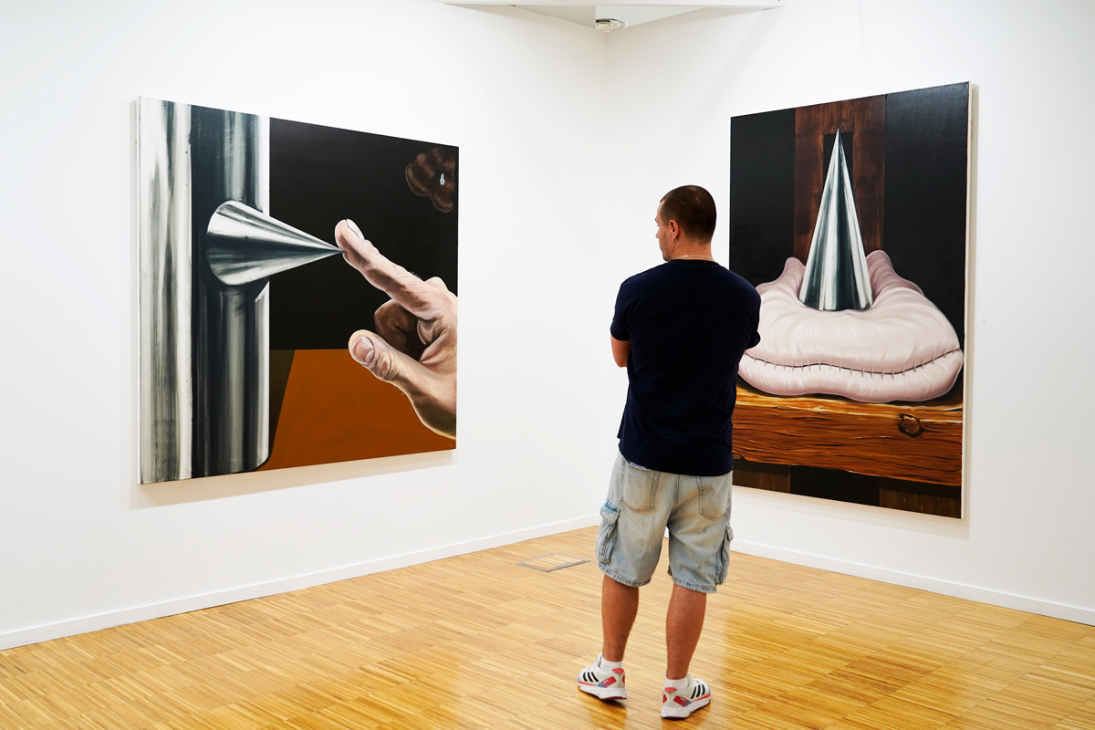 Visitante contempla obras de arte contemporáneo en un estand de ArteSantander 2026. Foto: Santi Ortiz.